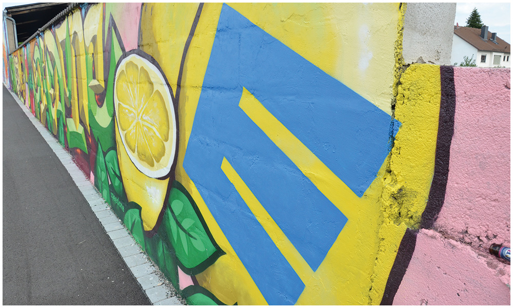 Das frische EDEKA-Logo ist ebenfalls Teil der neugestalteten Graffiti-Wand auf dem Parkplatz von EDEKA Azevedo.