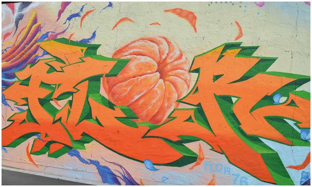 Eine frische Mandarine steht im Mmittelpunkt dieses Graffiti-Motivs.