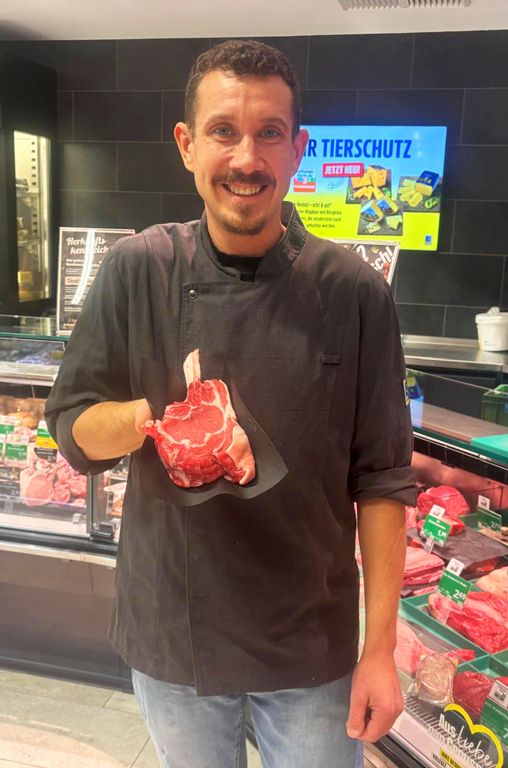 Mitarbeiter von EDEKA Azevedo mit Fleisch in der Hand